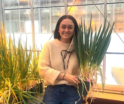 Ariana Forand, USask Master’s student, holding Welsh onions.