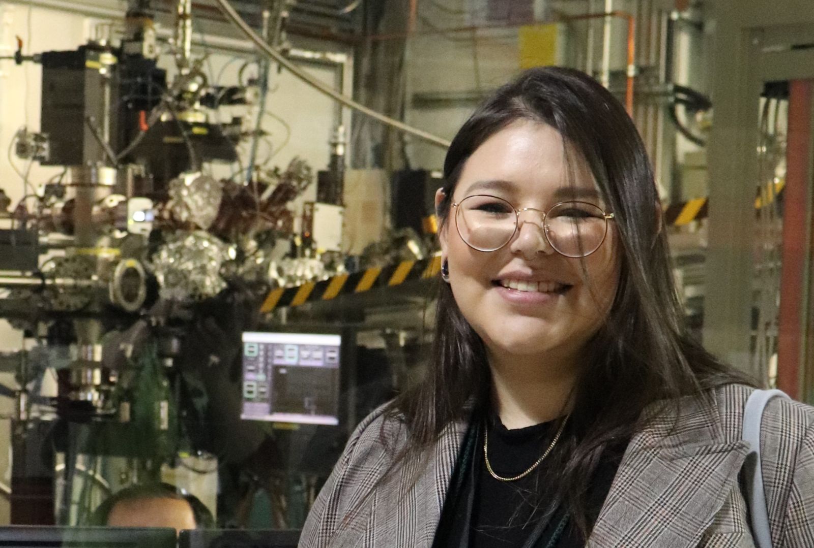 Julia Doucette-Garr in front of the REIXS beamline at the CLS.