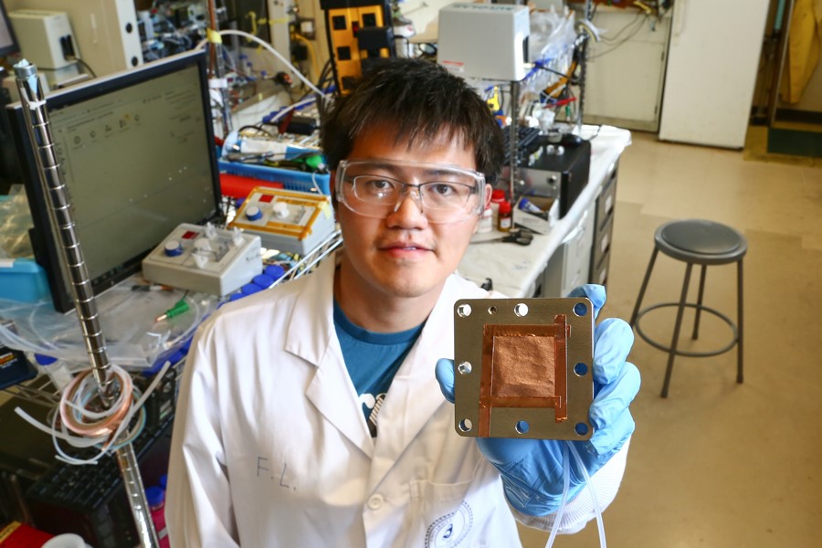 Fengwang Li demonstrates the copper-based catalyst that he and his collaborators have designed. Photo by Tyler Irving.