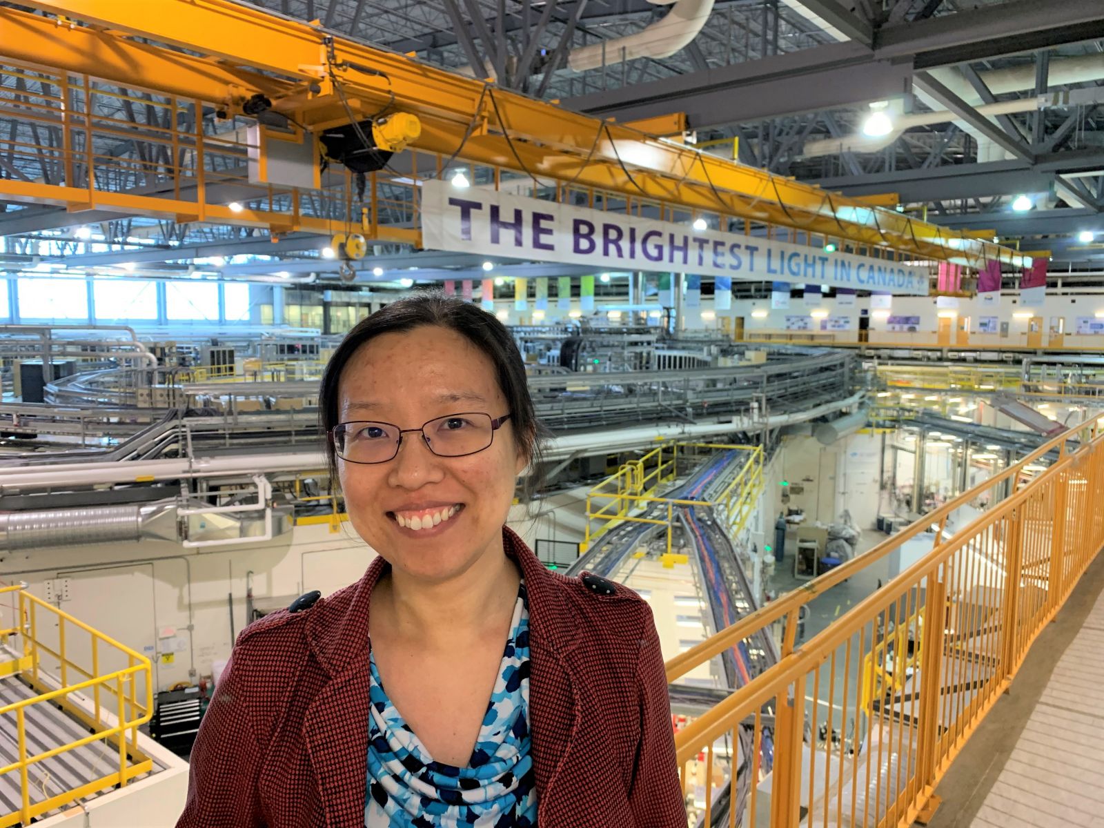 Na Liu standing in front of the Canadian Light Source synchrotron.