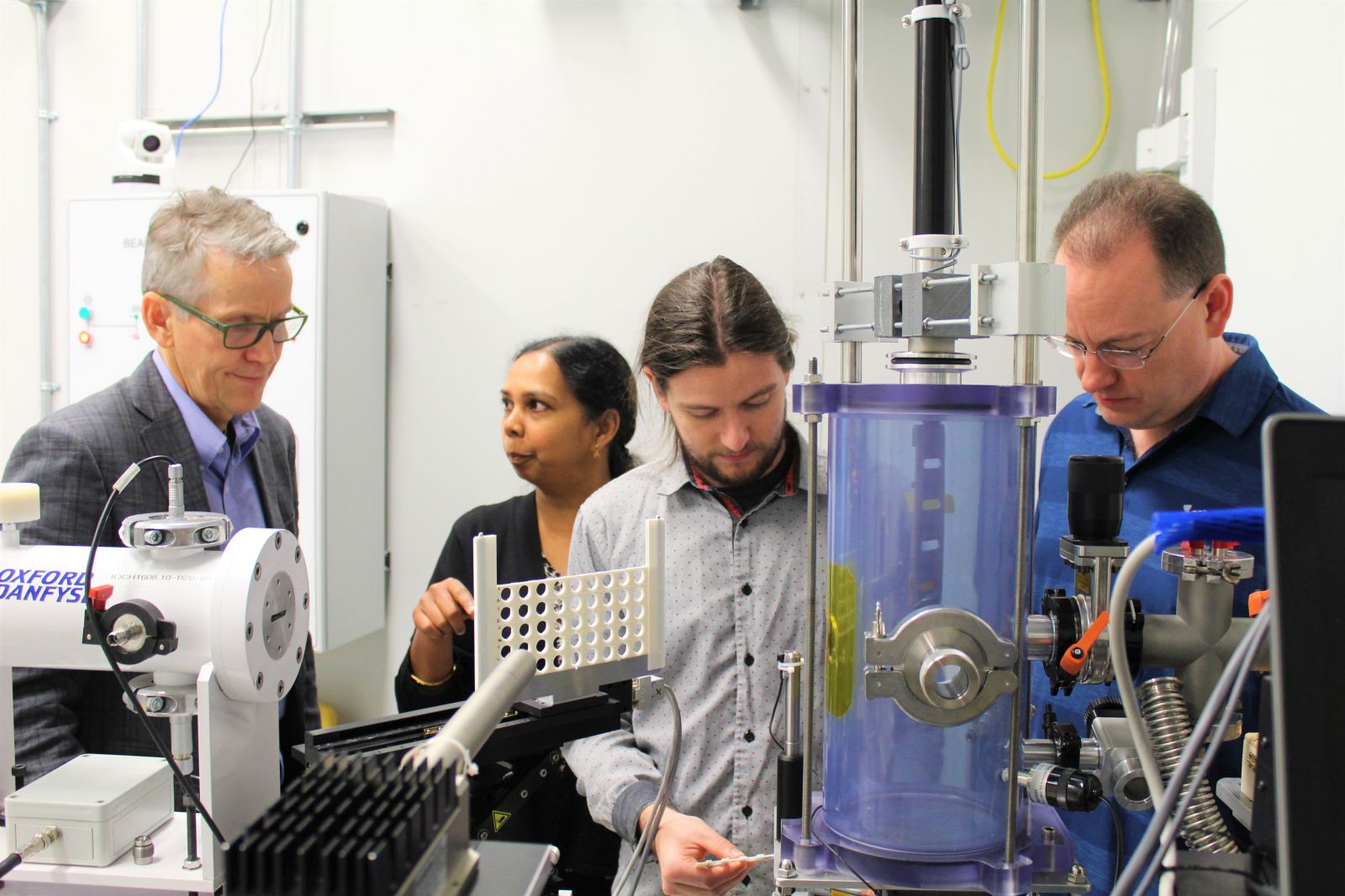 (Left to right) Warkentin, Karunakaran, Stobbs, and Muir working with pea samples at the IDEAS beamline.