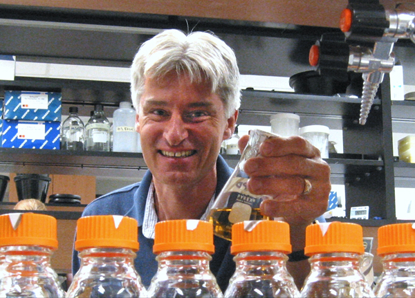 Dr. Clarke inspecting flasks of bacterial cultures in a student laboratory.