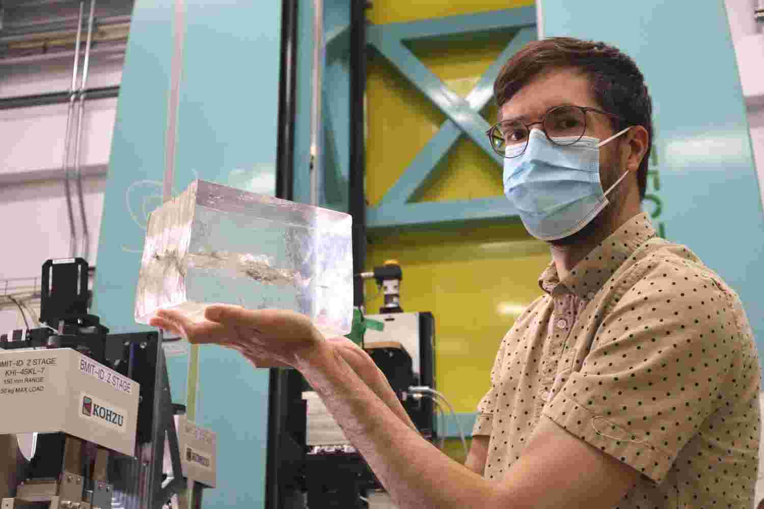 Adam Leontowich holding block of ballistic gelatin at the BMIT beamline at the CLS.