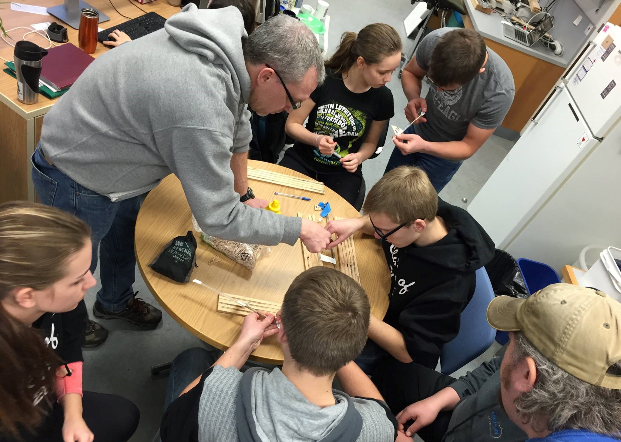 Students crowding around Dr. Colin Laroque at MAD Lab, learning about how tree cores are mounted to holders to collect dendrochronology data.